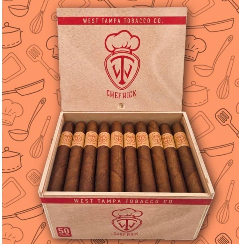 Open wooden cigar box labeled West Tampa Tobacco Co. and Chef Rick with 50 cigars arranged inside, backdrop of kitchen-pattern backdrop.