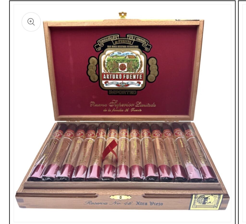 Open wooden cigar box with a row of cigars labeled Arturo Fuente Reserve No. 46 Extra Viejo inside the lid.